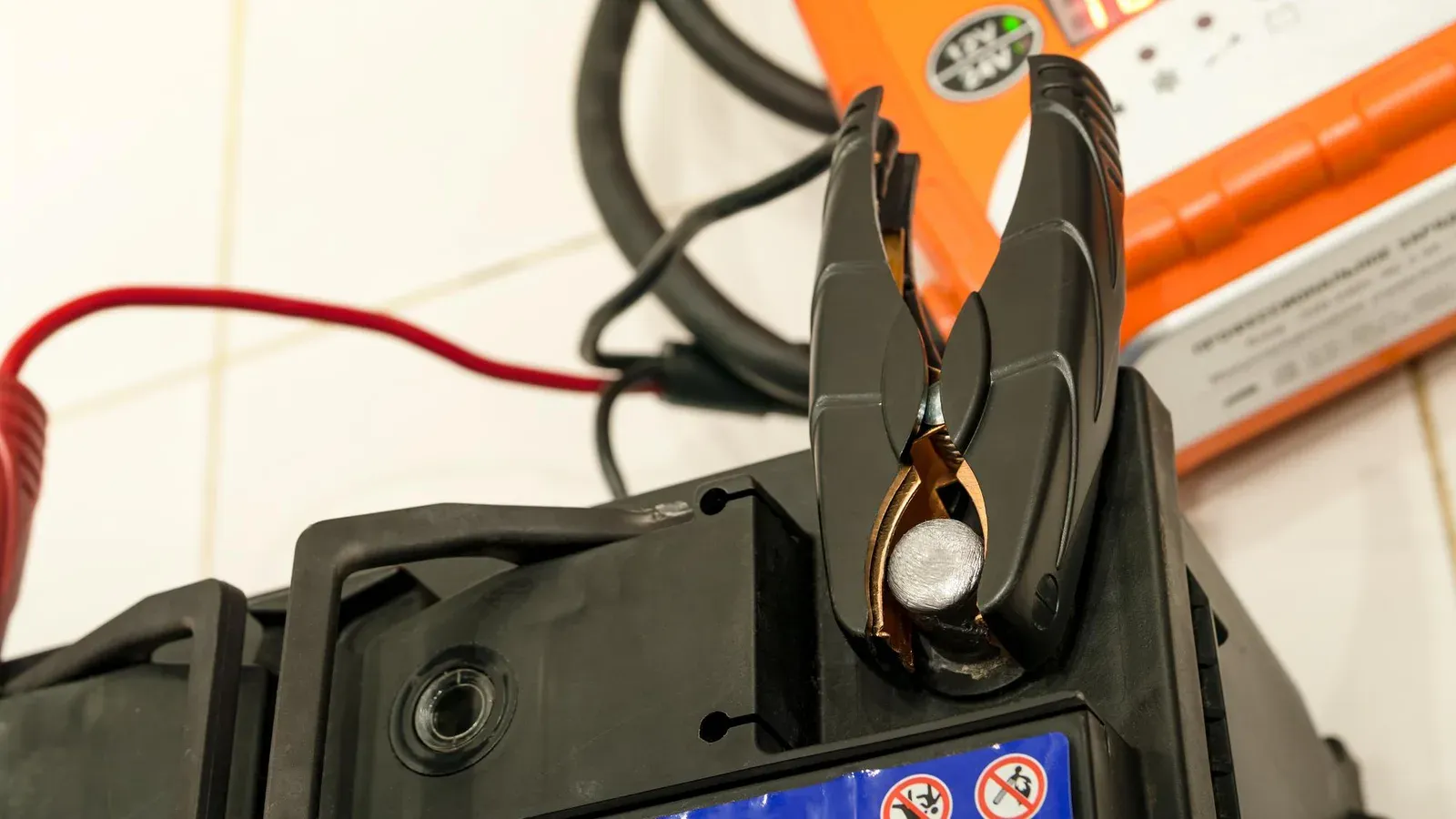 Batteriladdare ansluten till bilbatteri i garage vintertid