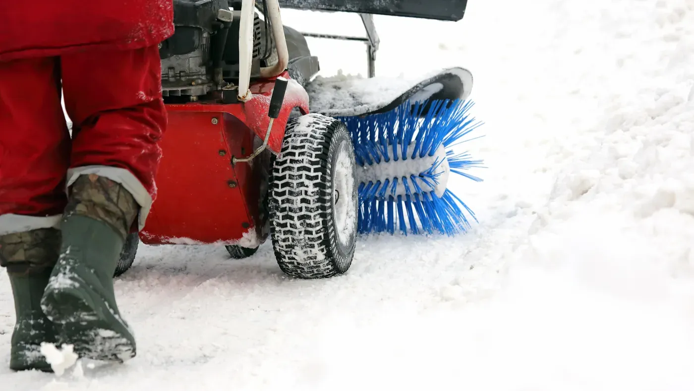 Isskrapa och vinterutrustning vid bil i snö